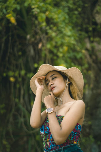 Portrait of a beautiful young woman wearing hat and close her eyes