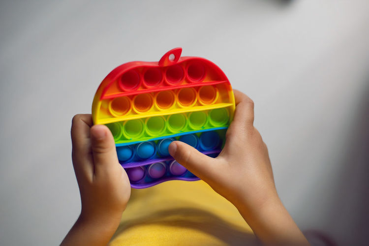 Child is playing with a colored toy pop it