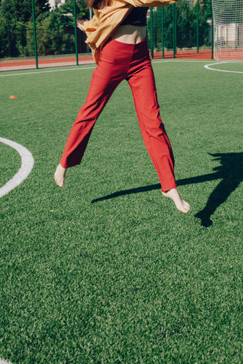 Low section of woman jumping on soccer field