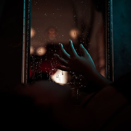 Person seen through wet glass window