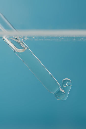 Pipette with cosmetic product in water with bubbles.