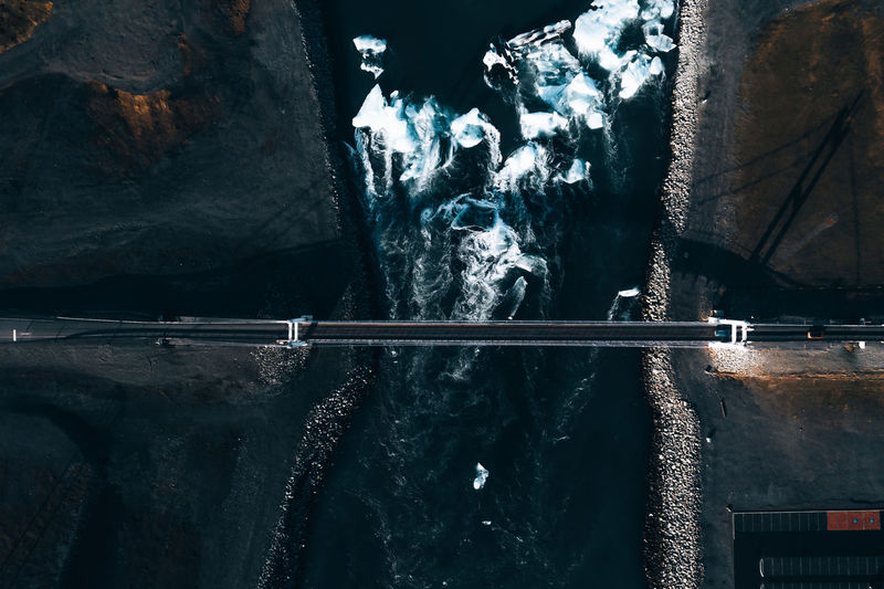 Scenic view of a bridge with passing icebergs under it