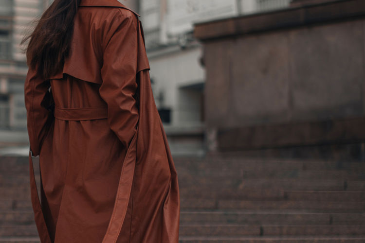 Autumn fashionable female outfit. stylish woman walking in brown coat outdoors. trendy modern