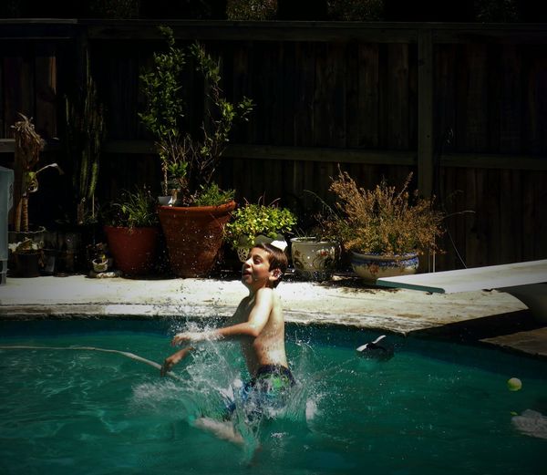 Side view of boy enjoying in swimming pool