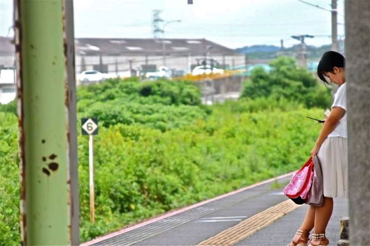 Side view of woman walking on road