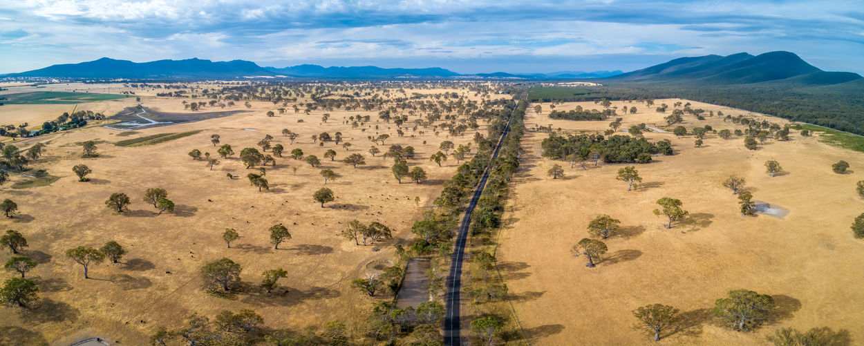 Scenic aerial panorama of rural highway passing through beautiful countryside in australia