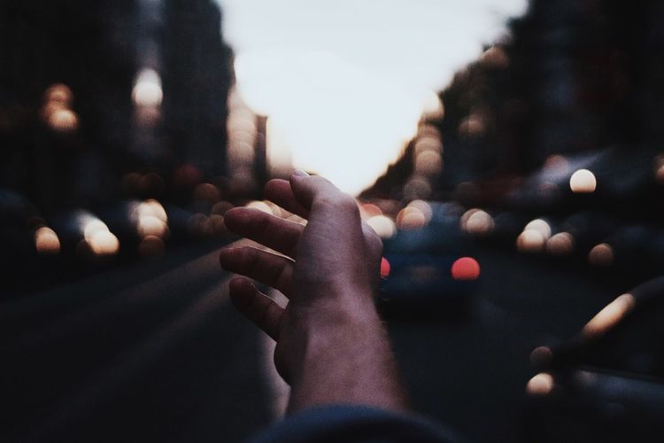 Cropped image of hand on road