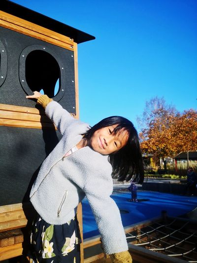 Cute asian girl playing at the playground during summer