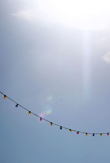 Low angle view of hanging flags against sky