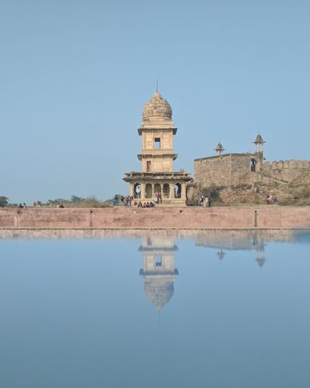 Reflection of ancient building in ancient pool against sky