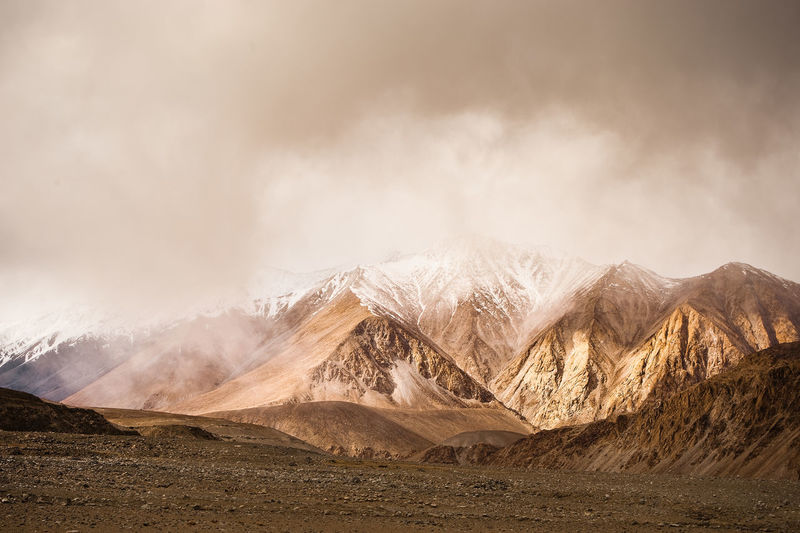 Scenic view of snowcapped mountains against cloudy sky at ladakh