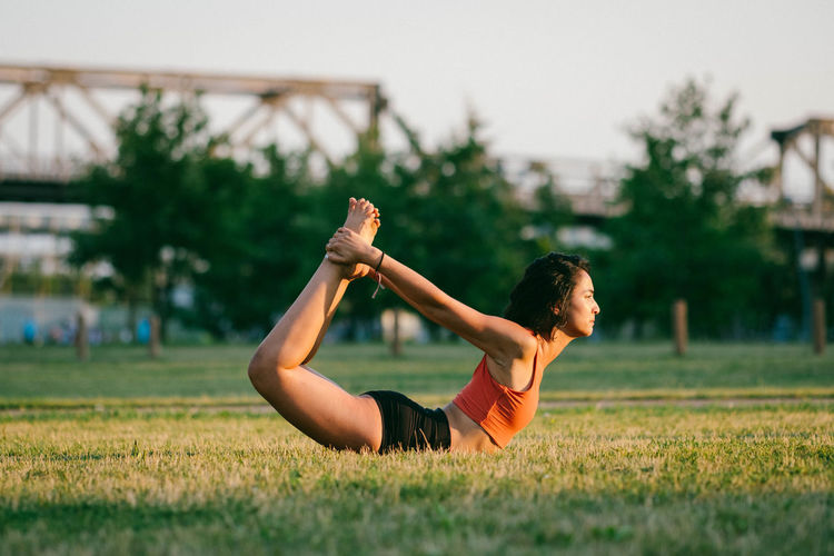 Woman exercising on grassy field