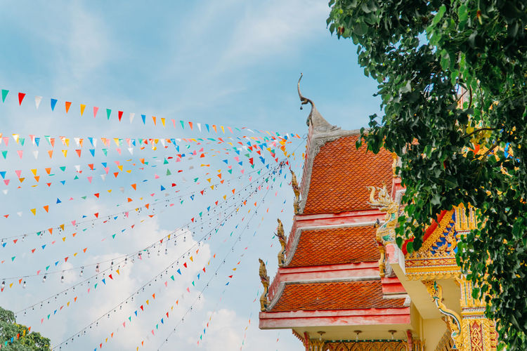 Temple fair. thai buddha church is decorated with colorful flags and lamp bulbs.