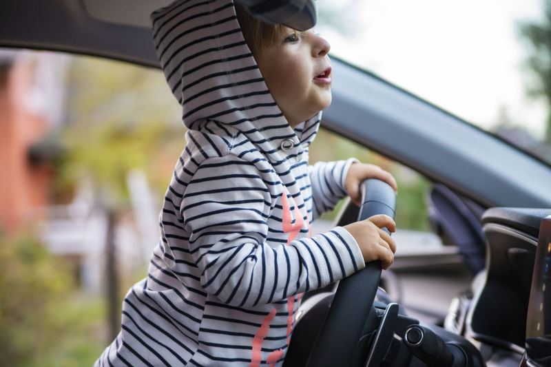 Cute girl holding steering wheel