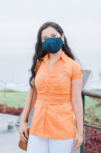 Young woman wearing mask standing outdoors
