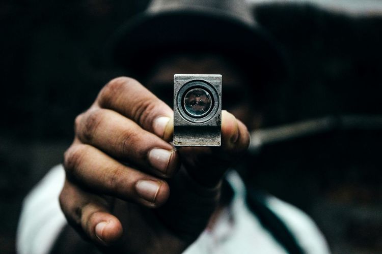 Close-up of man holding lens