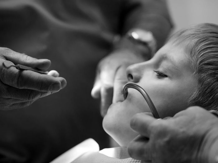 Close-up of dentist examining teeth of boy at clinic