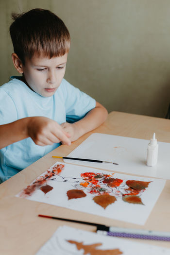 Boy painting on table