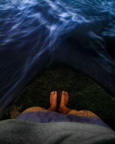 Low section of person relaxing in sea