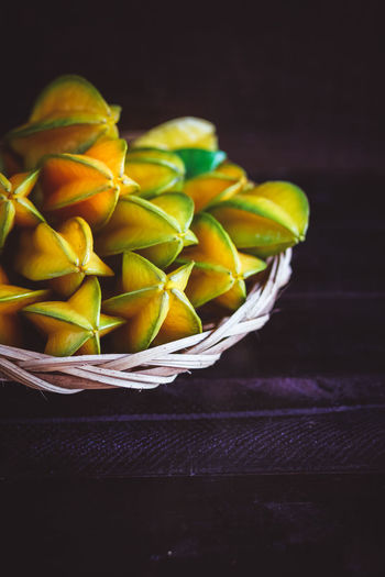 Close-up of starfruits in wicker basket on table