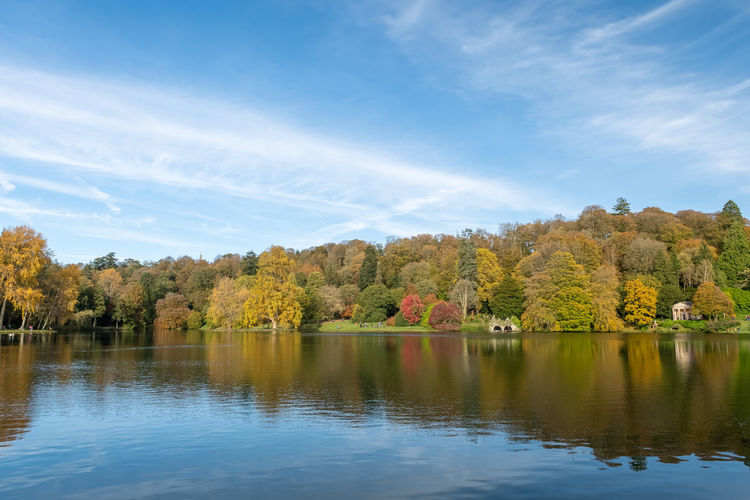 View of the autumn colours around the lake at stourhead gardens in wiltshire.