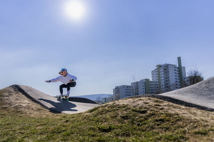 Young woman skateboarding at pump track on sunny day