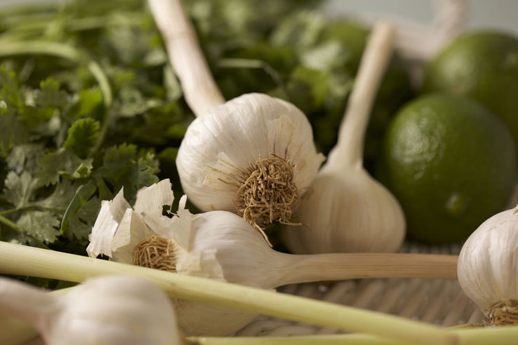 Close-up of garlic bulbs with cilantro and lemons on table