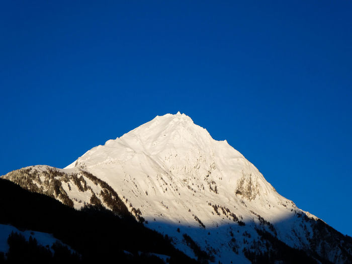Snowcapped mountains against clear blue sky