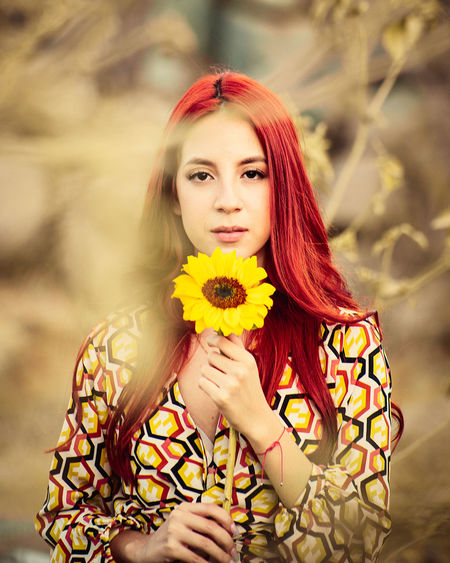 Portrait of beautiful woman holding flower