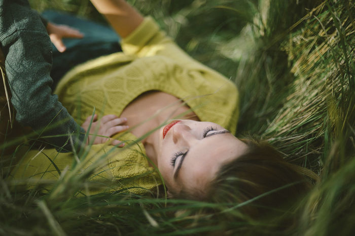 MIDSECTION OF WOMAN LYING ON GRASS