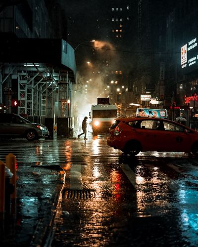 Cars on city street during rainy season at night