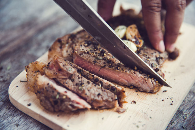 Cropped image of hand cutting meat