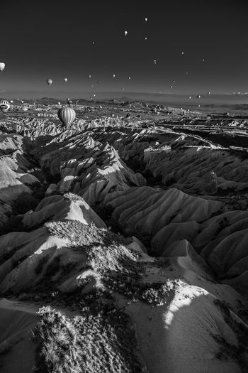 Hot air balloons over rocky mountains at cappadocia