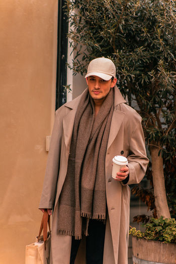 Portrait of young man standing against wall