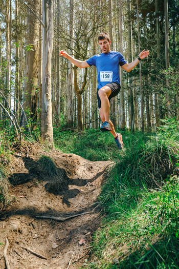 Full length of man jumping in forest