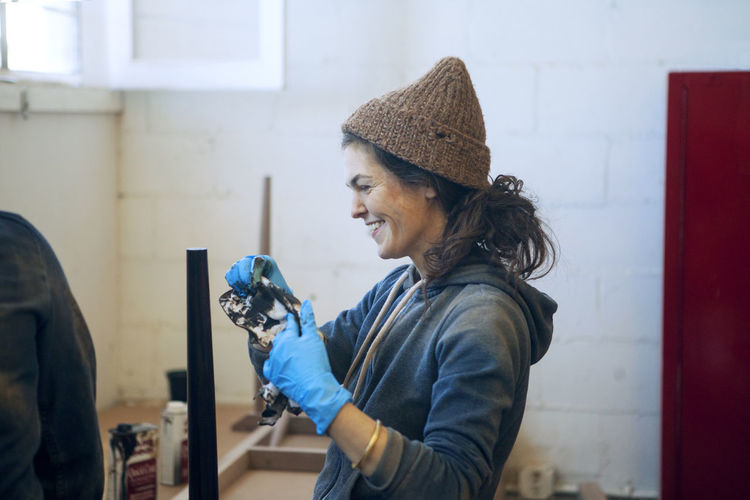 Side view of happy female carpenter in workshop