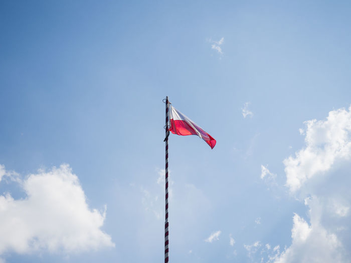 Low angle view of flag flags against sky