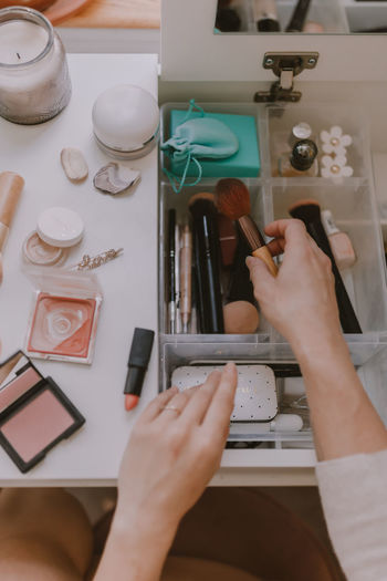 High angle view of woman holding make-up equipment