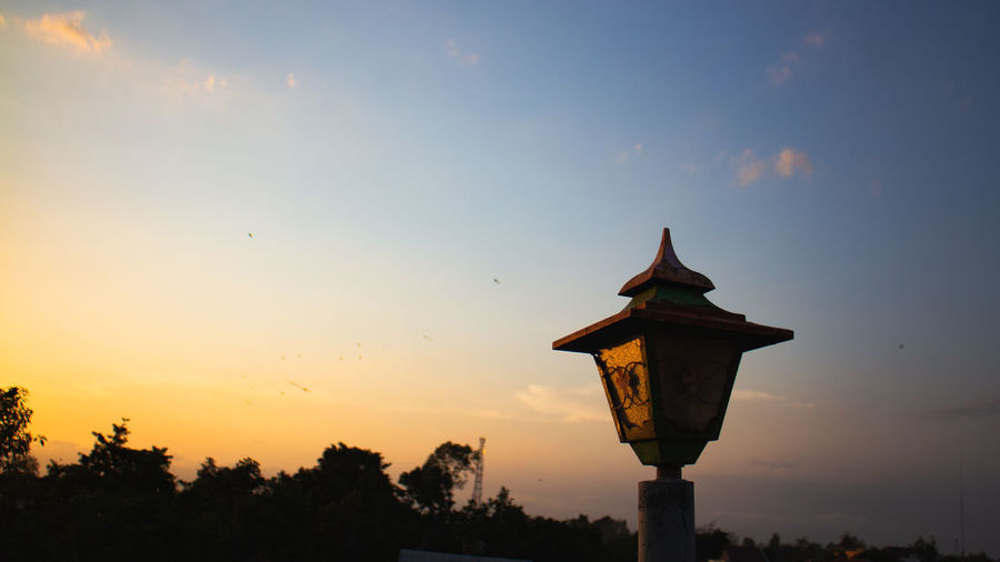 Low angle view of silhouette street light against sky during sunset