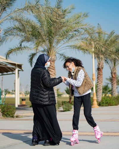 Saudi woman having fun against palm trees