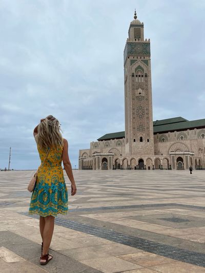 Rear view of woman standing against historic building