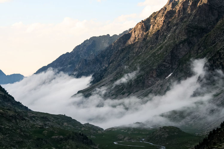 Scenic view of pyrenees against sky during foggy weather