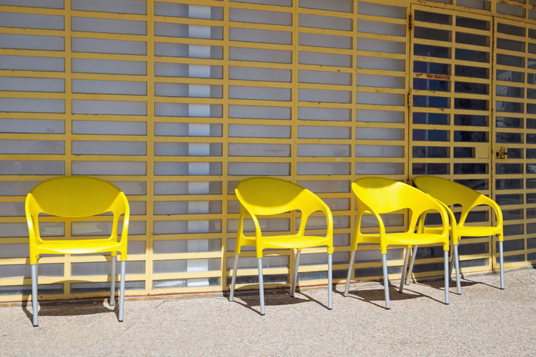 Yellow chairs against brick wall
