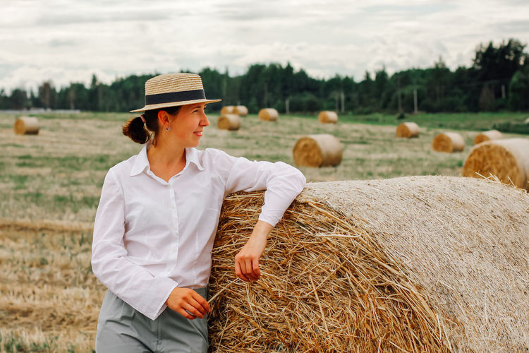 Rear view of woman standing on hay