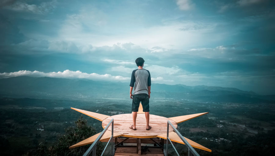 Rear view of man standing on observation point against sky