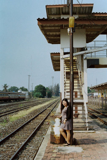 Woman sitting on railroad track