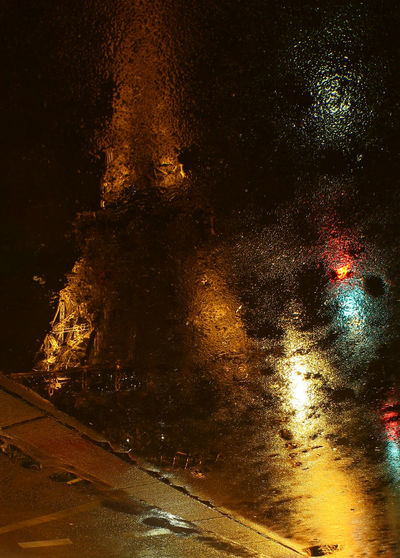 Close-up of wet car on road at night