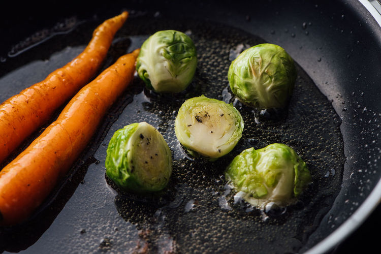 High angle view of carrots with brussels sprouts in cooking pan