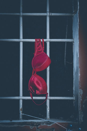 Close-up of red shoes hanging on window