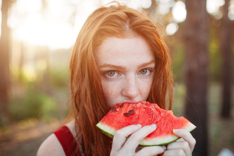 Close-up portrait of woman eating melon